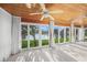 The sunroom features water views, white tile flooring, white curtains, and a wood plank ceiling at 655 Spanish Way, Longboat Key, FL 34228