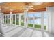 Sunroom overlooking the water, featuring tile flooring, a ceiling fan, and sliding glass doors at 655 Spanish Way, Longboat Key, FL 34228