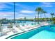 Outdoor pool area with lounge chairs, palm trees, and a waterfront view of the marina at 655 Spanish Way, Longboat Key, FL 34228