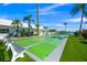 Shuffleboard courts near the water with benches, palm trees, and lush grass on a beautiful day at 655 Spanish Way, Longboat Key, FL 34228