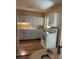 Functional kitchen with white cabinetry and laminate flooring at 6803 Washington Pl, Bradenton, FL 34207