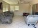 Inviting living space with tiled floor, gray sofa and chair, and bright natural light from windows at 6803 Washington Pl, Bradenton, FL 34207