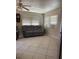Cozy living room featuring tiled flooring and a comfortable gray sofa set under bright windows at 6803 Washington Pl, Bradenton, FL 34207