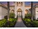 Grand entrance with ornate double doors, columns, and lush landscaping along walkway at 7144 Ashland Gln, Lakewood Ranch, FL 34202