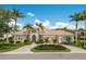 Stunning home with lush landscaping, a circular driveway, and a beautiful tile roof against a backdrop of blue skies at 7144 Ashland Gln, Lakewood Ranch, FL 34202