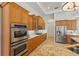 Modern kitchen featuring stainless steel appliances, granite countertops, and light wood cabinets at 7144 Ashland Gln, Lakewood Ranch, FL 34202