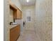 Functional laundry room featuring a sink, cabinetry, modern appliances, and patterned wallpaper at 7144 Ashland Gln, Lakewood Ranch, FL 34202
