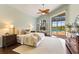 Tranquil main bedroom with a vaulted ceiling, wood floor, and access to the screened-in pool area at 7144 Ashland Gln, Lakewood Ranch, FL 34202