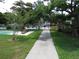 The walkway leads to the community swimming pool with a park bench to rest and enjoy nature at 7157 Fairway Bend Cir, Sarasota, FL 34243