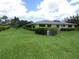 Beautiful home with a spacious green lawn, mature hedges, and a screened-in porch at 7157 Fairway Bend Cir, Sarasota, FL 34243