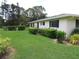 Beautiful home exterior with well-maintained lawn, lush landscaping, and dark shuttered windows at 7157 Fairway Bend Cir, Sarasota, FL 34243