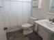 Cozy bathroom with a tiled floor, a pedestal sink and a shower with a white curtain at 7157 Fairway Bend Cir, Sarasota, FL 34243