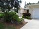 Charming home entrance with a decorative gate, lush landscaping, and a well-maintained walkway at 7157 Fairway Bend Cir, Sarasota, FL 34243