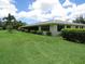 Well-maintained home exterior with lush green lawn, mature landscaping, and screened in lanai at 7157 Fairway Bend Cir, Sarasota, FL 34243
