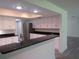 Bright kitchen with stainless appliances, granite counters, and white cabinets, open to the living room at 7157 Fairway Bend Cir, Sarasota, FL 34243
