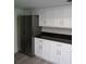 Modern kitchen features stainless steel refrigerator, white cabinets, and black countertop at 7157 Fairway Bend Cir, Sarasota, FL 34243