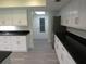 Kitchen featuring stainless appliances, granite counters, and many white cabinets leading to an exit door at 7157 Fairway Bend Cir, Sarasota, FL 34243
