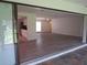 Spacious living area with wood flooring, sliding glass doors, and kitchen access at 7157 Fairway Bend Cir, Sarasota, FL 34243
