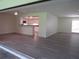 Open-concept living room featuring hardwood floors, a glimpse of the kitchen and ample natural light at 7157 Fairway Bend Cir, Sarasota, FL 34243