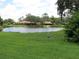 Scenic view of a tranquil pond surrounded by lush green grass and mature trees at 7157 Fairway Bend Cir, Sarasota, FL 34243