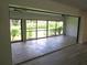Enclosed sunroom with tile flooring and sliding glass windows overlooking a lush green yard at 7157 Fairway Bend Cir, Sarasota, FL 34243