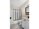Bathroom featuring glass enclosed tub, dark hardware, and light walls at 719 22Nd W St, Bradenton, FL 34205