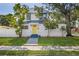 Charming home with a bright yellow door, complemented by lush landscaping and mature trees at 719 22Nd W St, Bradenton, FL 34205
