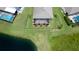 Aerial view of a backyard with a screened lanai, landscaping, and a serene pond, providing privacy and relaxation at 7364 47Th Avenue E Cir, Bradenton, FL 34203