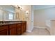 Bathroom with granite countertops, dark cabinets, a tiled floor, and a separate tub at 7364 47Th Avenue E Cir, Bradenton, FL 34203