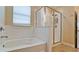 Bathroom featuring a tiled tub, separate glass shower, tiled walls, and window at 7364 47Th Avenue E Cir, Bradenton, FL 34203