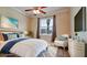 Bedroom with neutral colors, a ceiling fan, a wicker chair, and beach-themed art at 7364 47Th Avenue E Cir, Bradenton, FL 34203