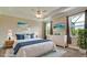 Comfortable staged main bedroom with ensuite, beach-themed artwork, ceiling fan, and plenty of natural light at 7364 47Th Avenue E Cir, Bradenton, FL 34203