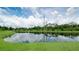 Scenic pond with lush green banks, reflecting the sky and trees, adding tranquility to the property at 7364 47Th Avenue E Cir, Bradenton, FL 34203