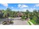 Residential home on a private lot with a circular driveway, mature trees, and lush landscaping at 7628 Haddington Cv, Lakewood Ranch, FL 34202