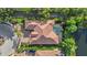 Aerial view of a luxury home with a tile roof, pool, and lush landscaping, nestled in a serene neighborhood at 7628 Haddington Cv, Lakewood Ranch, FL 34202