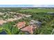 An aerial view of beautiful homes with terracotta roofs, mature trees, a golf course and a pond at 7628 Haddington Cv, Lakewood Ranch, FL 34202