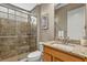 Bathroom with glass shower, neutral tile, granite counters and wood vanity at 7628 Haddington Cv, Lakewood Ranch, FL 34202