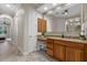Bright bathroom with double sinks, granite countertops, and vanity area, along with modern tile floors at 7628 Haddington Cv, Lakewood Ranch, FL 34202