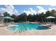 Large community pool area with plenty of seating and umbrellas to provide a refreshing and comfortable experience at 7628 Haddington Cv, Lakewood Ranch, FL 34202