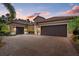 Home with tile roof, three car garage, brick driveway, manicured lawn at dusk at 7628 Haddington Cv, Lakewood Ranch, FL 34202