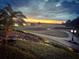 Scenic sunset view overlooking a golf course with lush greenery and a tranquil lake creating an idyllic setting at 7628 Haddington Cv, Lakewood Ranch, FL 34202