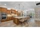 Open kitchen design with island seating, pendant lighting, stainless appliances, and custom cabinets at 7628 Haddington Cv, Lakewood Ranch, FL 34202