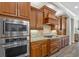 Close up of kitchen showcasing stainless steel appliances and custom wood range hood at 7628 Haddington Cv, Lakewood Ranch, FL 34202