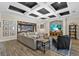 Bright living room with coffered ceiling, opening to a screened patio, and entertainment center with stone accents at 7628 Haddington Cv, Lakewood Ranch, FL 34202