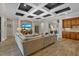 Comfortable living room with coffered ceilings, hardwood floors, and an entertainment center, open to the kitchen at 7628 Haddington Cv, Lakewood Ranch, FL 34202