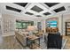 Comfortable living room with coffered ceilings, hardwood floors, and an entertainment center, open to the patio at 7628 Haddington Cv, Lakewood Ranch, FL 34202