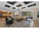 Open floor plan with coffered ceilings in the living room connecting to a modern kitchen at 7628 Haddington Cv, Lakewood Ranch, FL 34202
