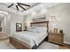 Inviting main bedroom with tray ceiling, neutral tones, and an ensuite bathroom with hardwood floors at 7628 Haddington Cv, Lakewood Ranch, FL 34202