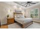 Main bedroom features tray ceiling, wood floors, natural light and decorative lighting at 7628 Haddington Cv, Lakewood Ranch, FL 34202