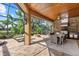 Expansive outdoor living space with a kitchen, dining area, lounge chairs, and a fire pit, perfect for entertaining at 7628 Haddington Cv, Lakewood Ranch, FL 34202